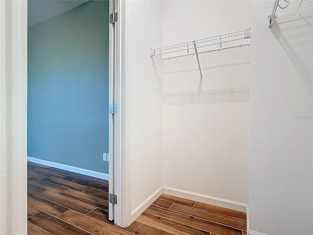 walk in closet with wood finish floors