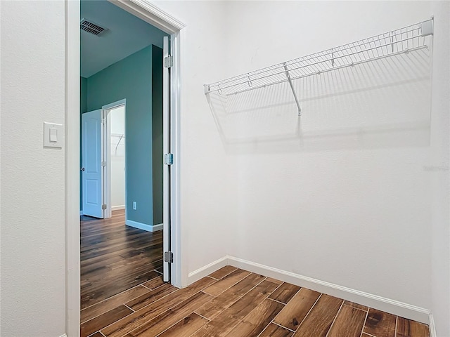 walk in closet featuring visible vents and dark wood finished floors