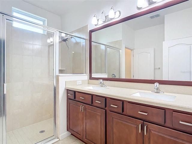 full bathroom featuring double vanity, a stall shower, a sink, and visible vents