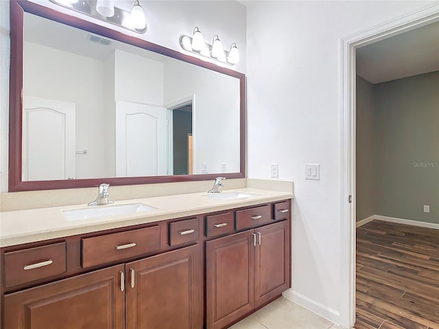 full bathroom with visible vents, a sink, baseboards, and double vanity