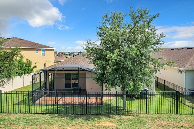 back of property featuring a fenced backyard, roof with shingles, a lanai, a yard, and stucco siding