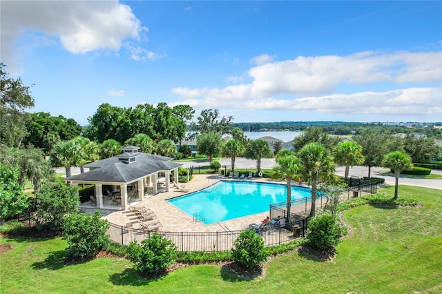 pool featuring a yard, a patio, and fence