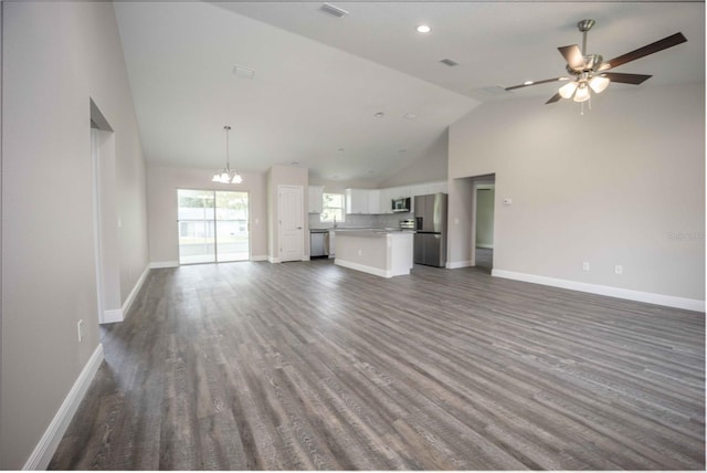 unfurnished living room with high vaulted ceiling, ceiling fan with notable chandelier, and hardwood / wood-style floors