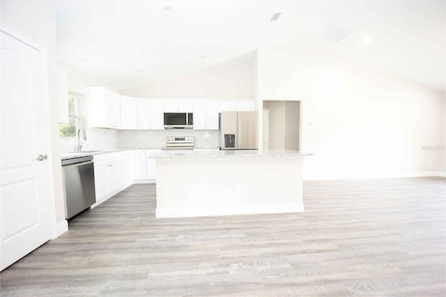 kitchen featuring light hardwood / wood-style flooring, white cabinets, a kitchen island, appliances with stainless steel finishes, and high vaulted ceiling