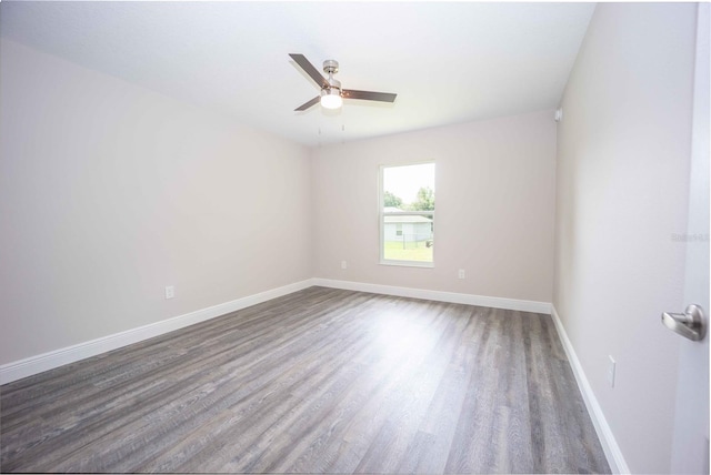 empty room with ceiling fan and dark wood-type flooring