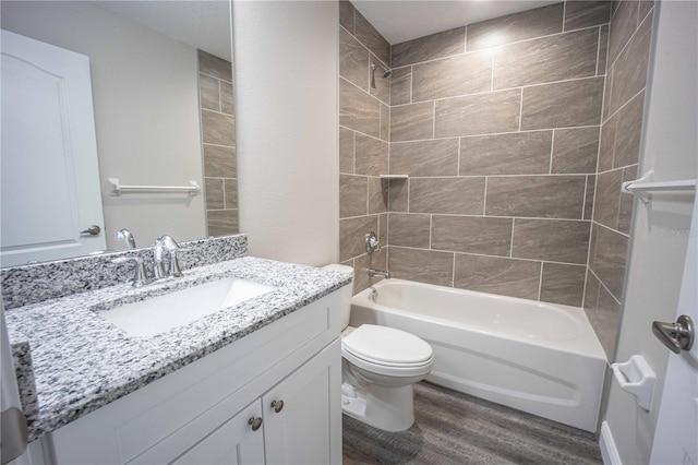 full bathroom with vanity, tiled shower / bath combo, toilet, and wood-type flooring