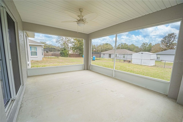 unfurnished sunroom with ceiling fan