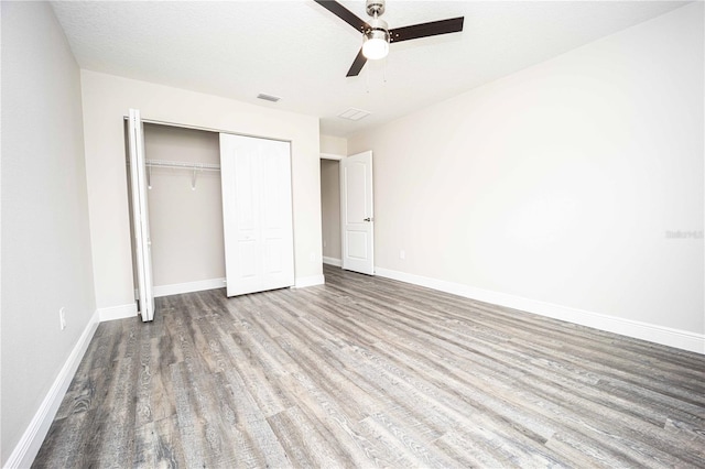 unfurnished bedroom featuring a textured ceiling, light hardwood / wood-style flooring, a closet, and ceiling fan