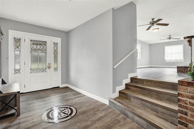 entrance foyer featuring ceiling fan, dark hardwood / wood-style flooring, and a textured ceiling