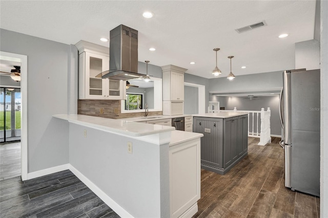 kitchen featuring kitchen peninsula, stainless steel fridge, pendant lighting, gray cabinets, and island range hood