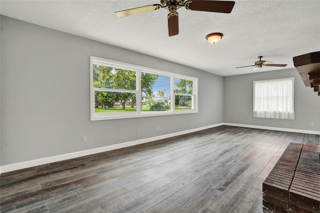 spare room with a textured ceiling and dark hardwood / wood-style flooring