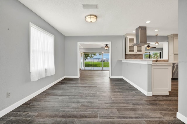 interior space featuring ceiling fan, plenty of natural light, and dark hardwood / wood-style floors