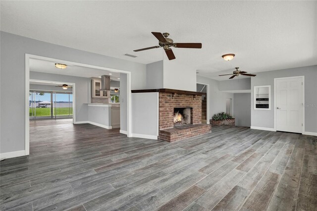 unfurnished living room with a fireplace, a textured ceiling, and hardwood / wood-style flooring