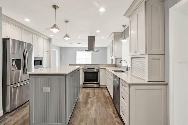 kitchen featuring hardwood / wood-style floors, a center island, appliances with stainless steel finishes, decorative light fixtures, and island exhaust hood