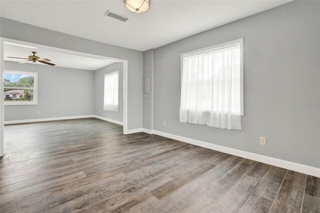 empty room with ceiling fan and dark wood-type flooring