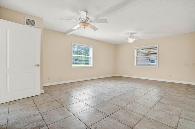 tiled empty room with a textured ceiling and ceiling fan