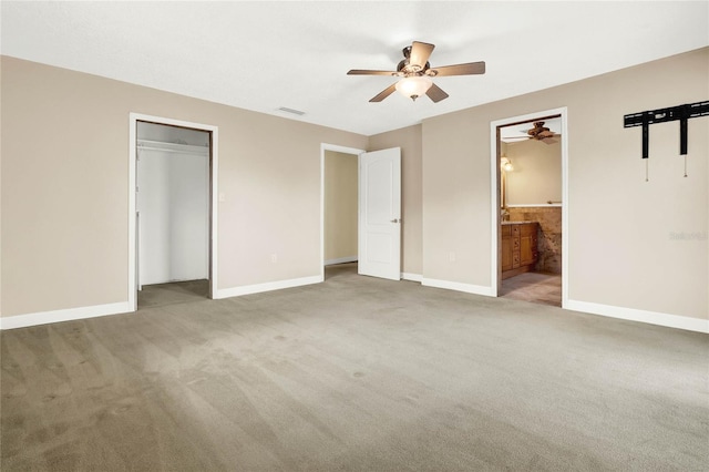 unfurnished bedroom featuring ensuite bath, ceiling fan, a closet, and light colored carpet