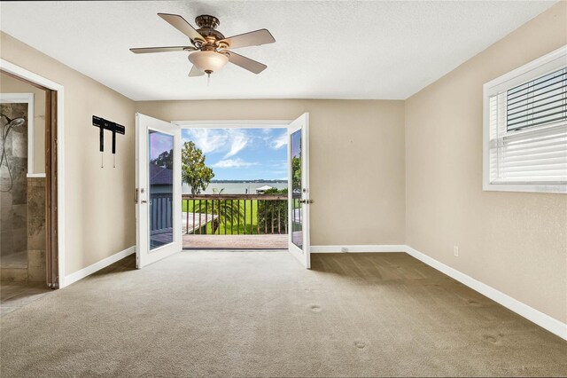 unfurnished room with ceiling fan, carpet floors, a textured ceiling, and french doors