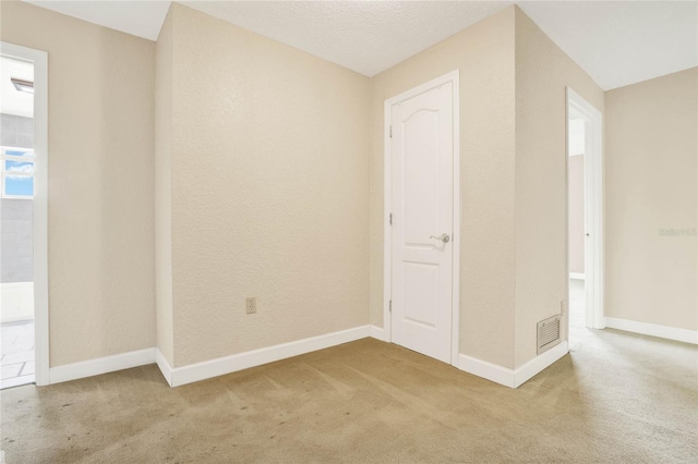 empty room featuring carpet flooring and a textured ceiling