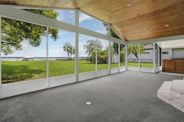 unfurnished sunroom featuring a water view, lofted ceiling, and wood ceiling