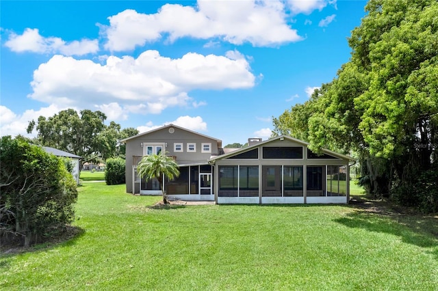 rear view of house featuring a lawn and a sunroom