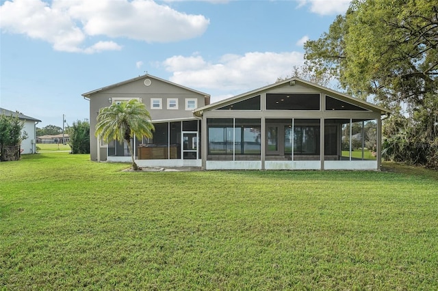 rear view of property with a yard and a sunroom