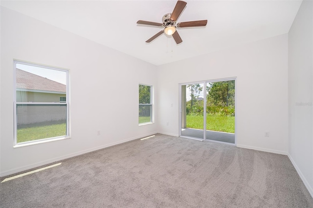 carpeted empty room with a wealth of natural light and ceiling fan