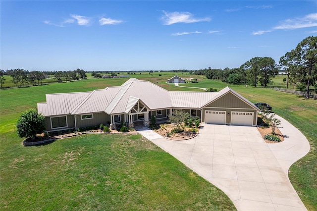 view of front of property featuring a garage, a rural view, and a front lawn