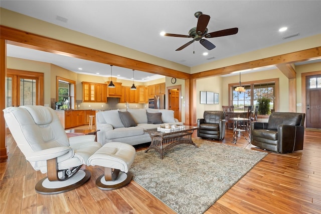 living room featuring ceiling fan, plenty of natural light, sink, and light hardwood / wood-style flooring