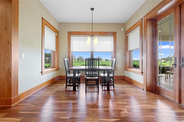 dining area with hardwood / wood-style floors and a notable chandelier