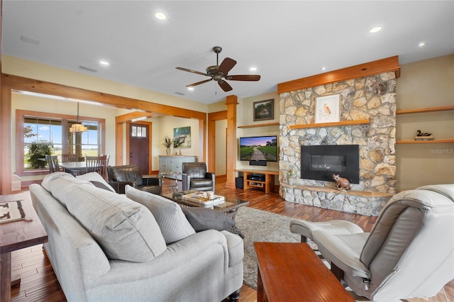 living room with a fireplace, wood-type flooring, and ceiling fan