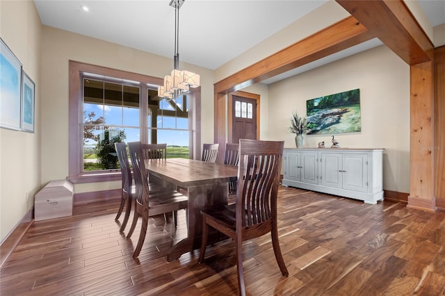 dining area with dark hardwood / wood-style flooring, a healthy amount of sunlight, and an inviting chandelier