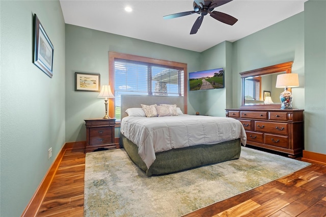 bedroom featuring dark hardwood / wood-style flooring, multiple windows, and ceiling fan