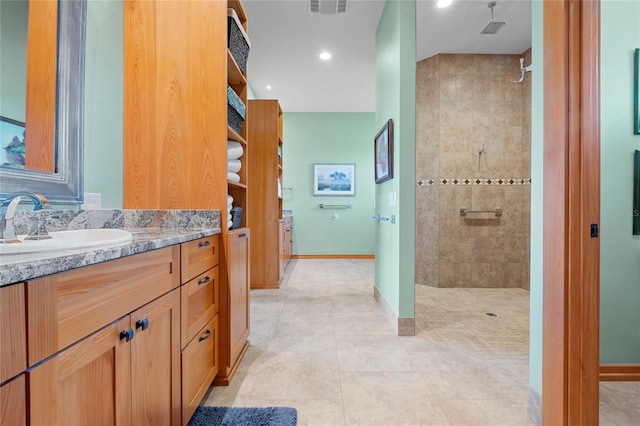 bathroom featuring tiled shower, vanity, and tile patterned floors