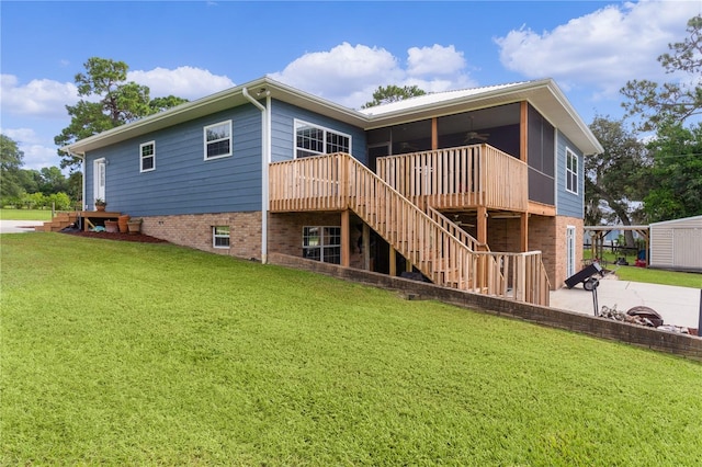 back of property with a wooden deck, a patio, a yard, and a storage shed