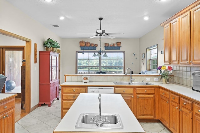 kitchen with tasteful backsplash, light tile patterned floors, white dishwasher, ceiling fan, and sink