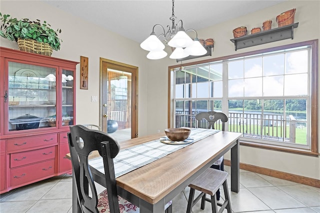 tiled dining room featuring a water view and a notable chandelier