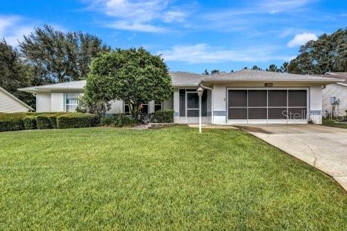 ranch-style home with a garage and a front yard