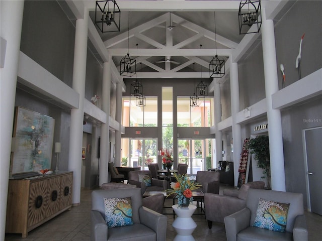 living room featuring an inviting chandelier, a high ceiling, and beamed ceiling