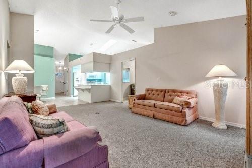 carpeted living room with ceiling fan