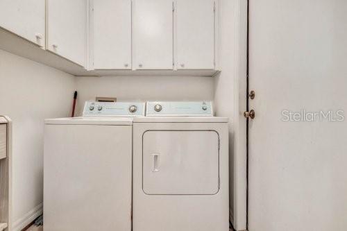 laundry area featuring washing machine and dryer and cabinets