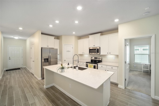 kitchen with white cabinetry, sink, an island with sink, and appliances with stainless steel finishes