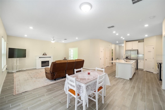 dining room with ceiling fan and sink