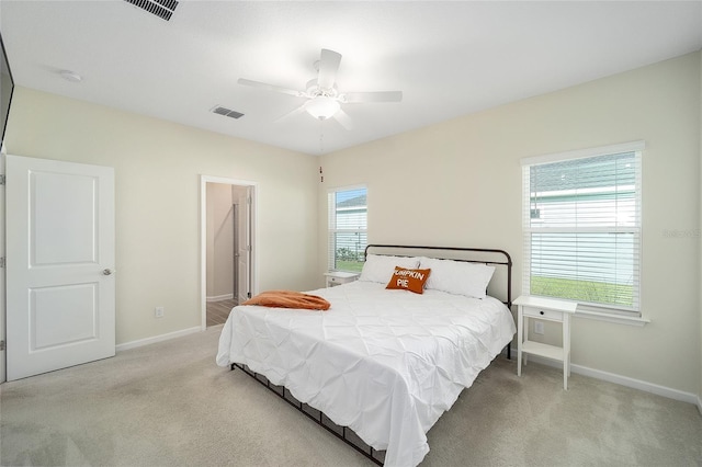 carpeted bedroom with ceiling fan and multiple windows