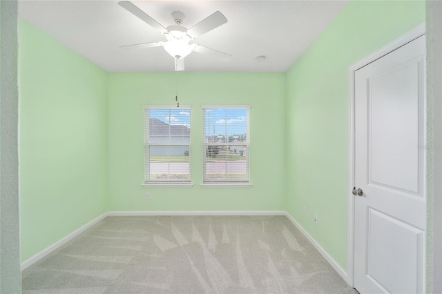 carpeted spare room featuring ceiling fan