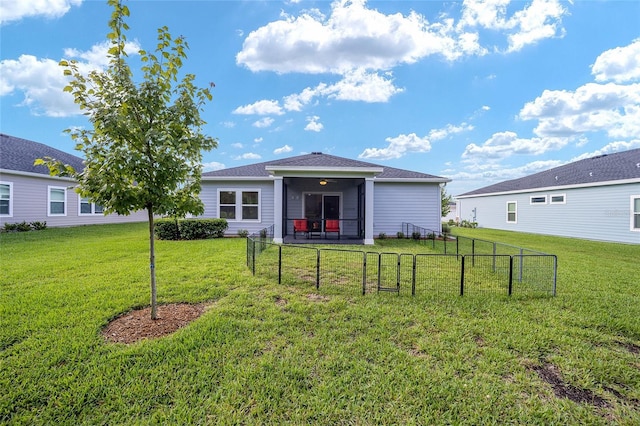 rear view of house featuring a sunroom and a lawn