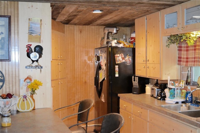 kitchen with light brown cabinets, wood ceiling, sink, and wooden walls