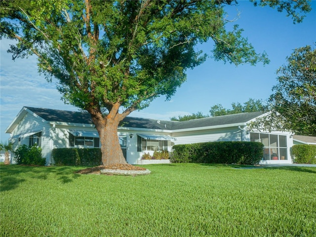 view of front of property with a sunroom and a front lawn