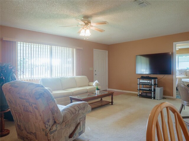 carpeted living room featuring a textured ceiling and ceiling fan