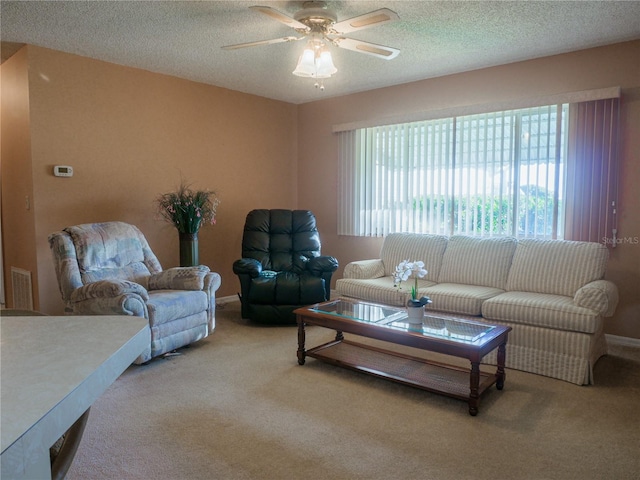 carpeted living room featuring ceiling fan and a textured ceiling